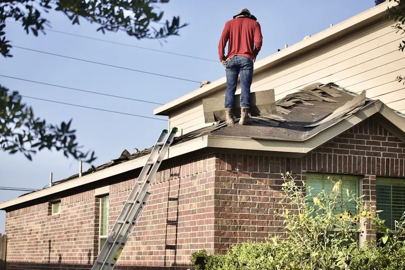Professional roofer working on a residential roof in Armistead Gardens